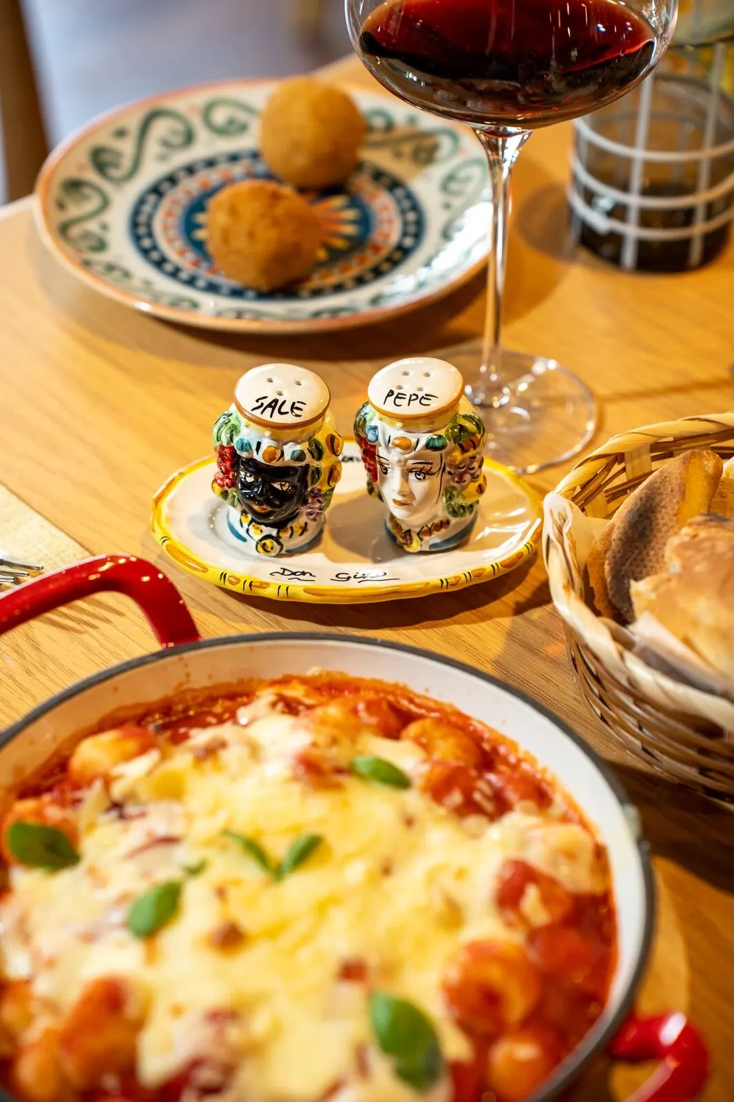 Arancini and a glass of red, with the salt and pepper heads