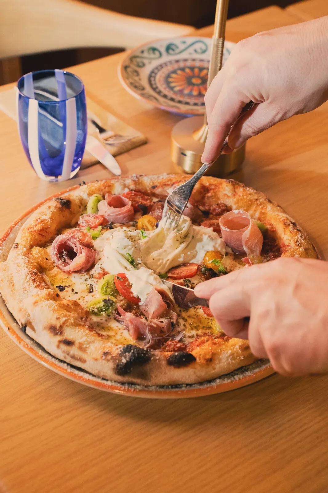 A pizza being cut at the table