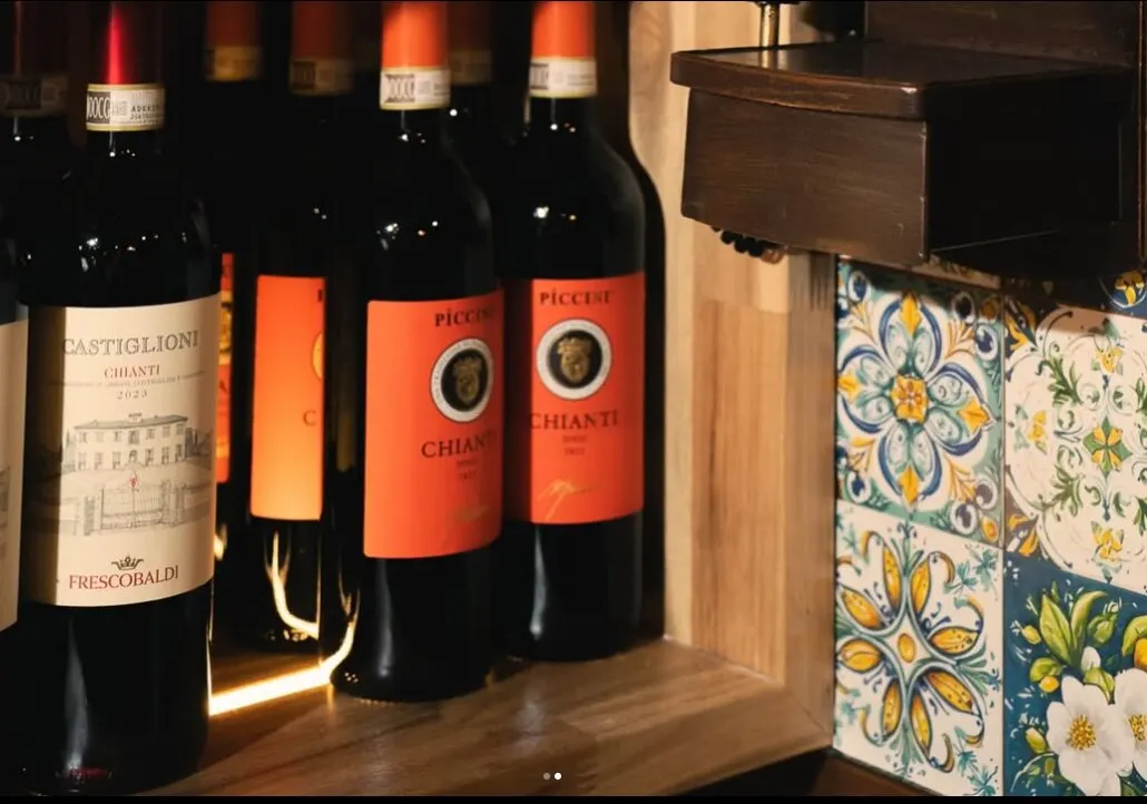 Chianti and Italian reds on the shelf beside the painted tiles